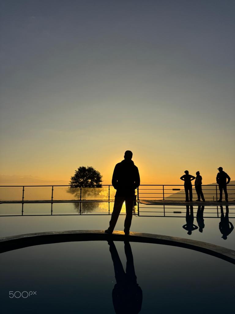 Silhouette of people standing against the sky during sunrise